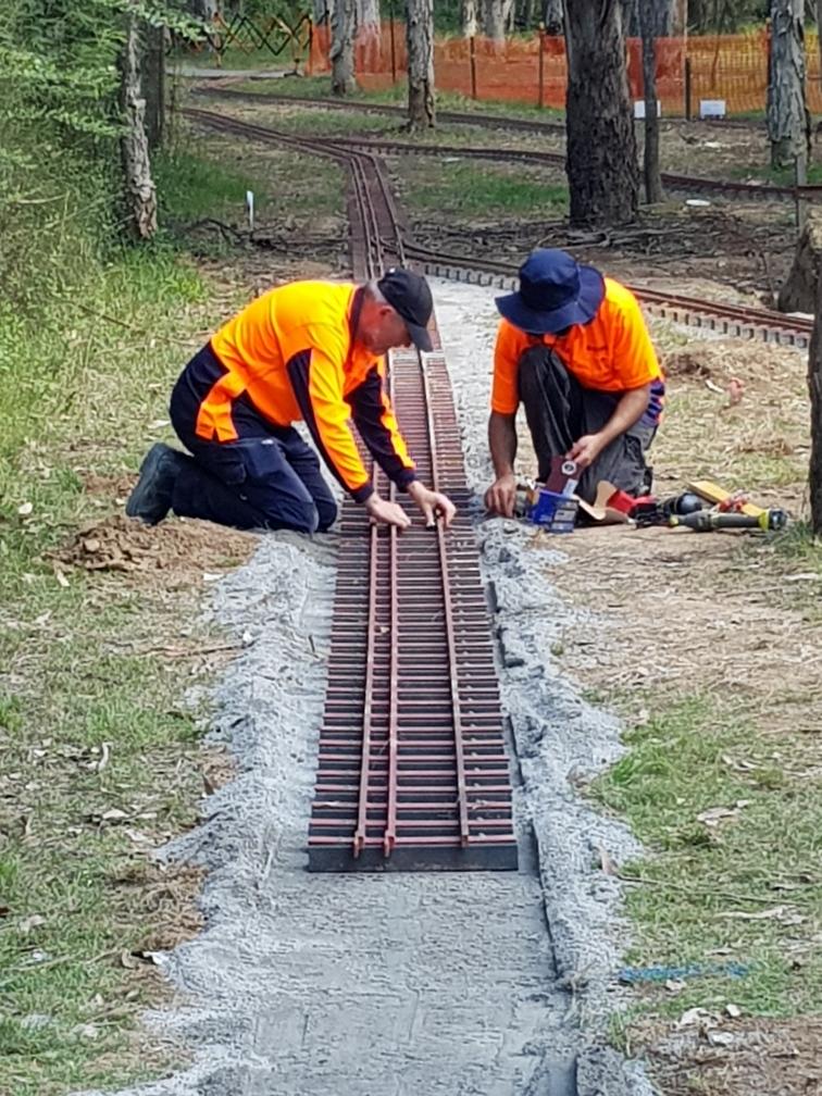 Club members laying miniature railway track